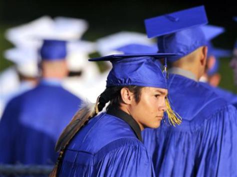 Christian Titman walks into Lamonica Stadium for Clovis High's graduation ceremony Thursday, June 4, 2015, in Clovis, Calif. The Native American student is wearing an eagle feather to his high school graduation after resolving a court fight with a California school district over the sacred object. (Eric Paul Zamora/The Fresno Bee via AP)